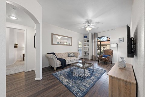 a living room with furniture and a ceiling fan