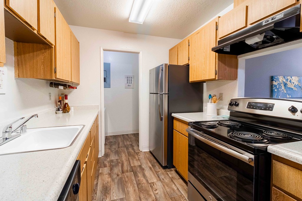 A kitchen with wooden cabinets and a black refrigerator.