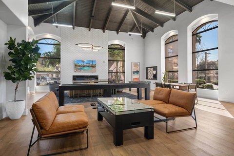 A living room with a brown leather chair and a glass table.