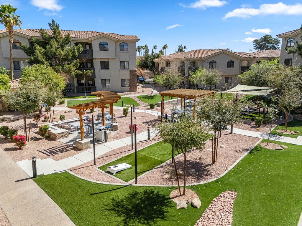 A sunny day at a residential complex with a playground and trees.