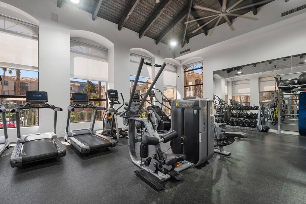 A gym with treadmills, elliptical machines, and other exercise equipment.