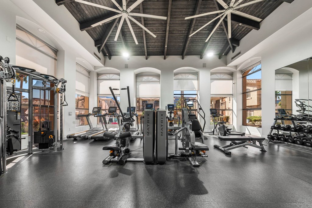 A gym with a variety of equipment including treadmills, stationary bikes, and weight machines.