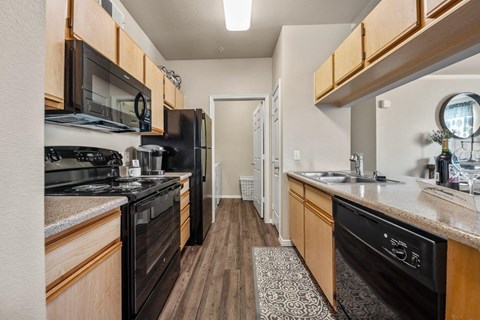 a kitchen with black appliances and wooden cabinets
