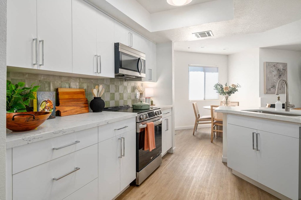 a kitchen with white cabinets and stainless steel appliances