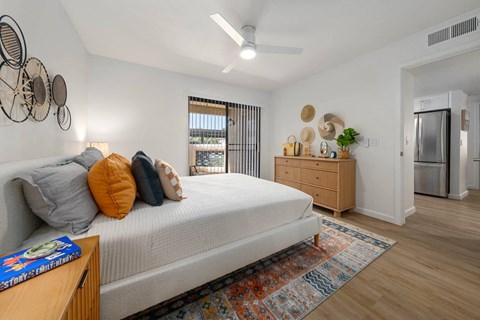 a bedroom with a bed and a refrigerator