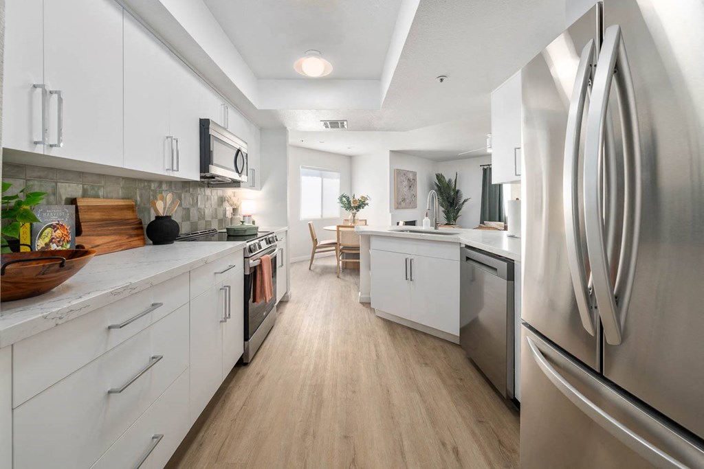 a kitchen with white cabinets and stainless steel appliances