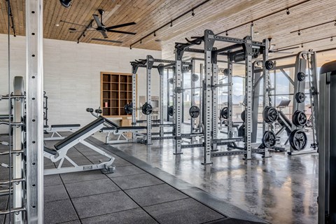 A gym with a variety of weightlifting equipment.