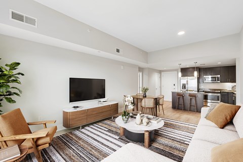 A modern living room with a television, a chair, and a coffee table.