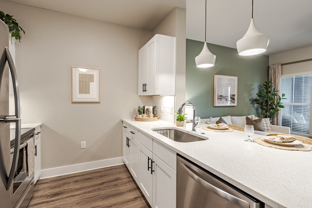 A kitchen with white cabinets and a stainless steel dishwasher.
