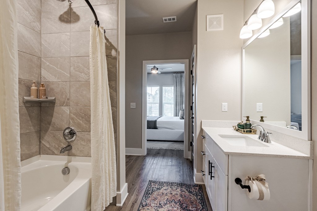 A bathroom with a white tub and a white sink.