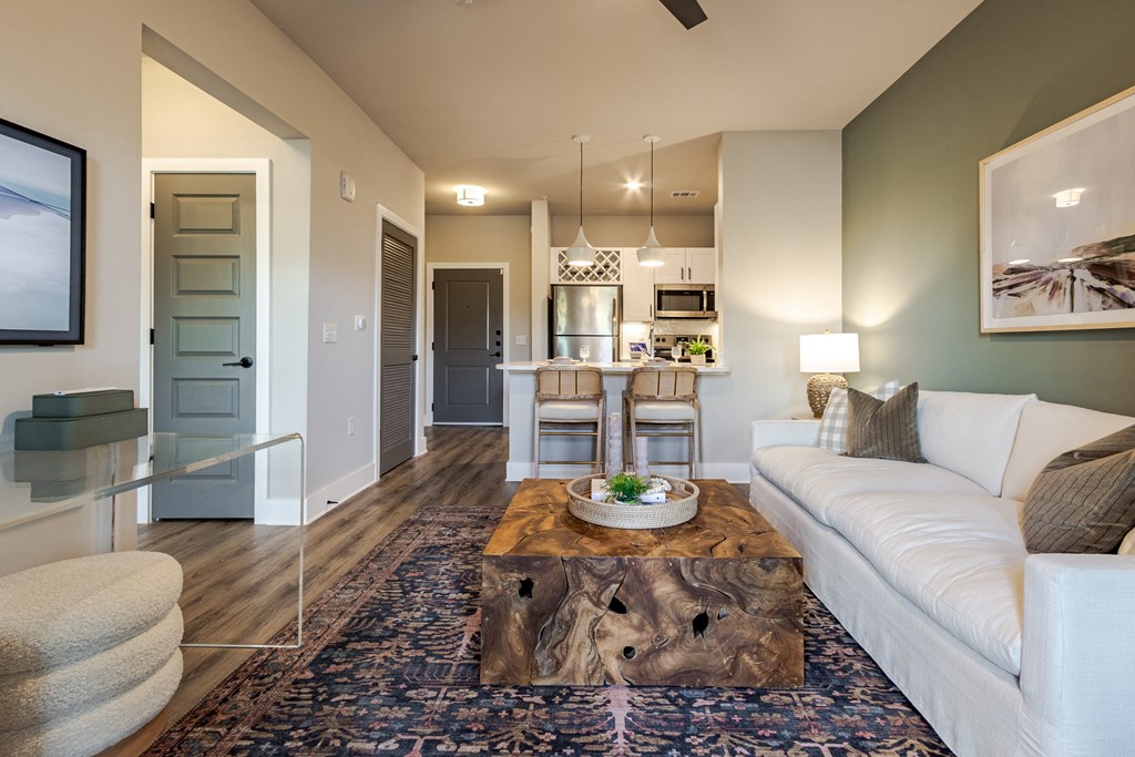 A modern living room with a white couch and a coffee table in the center.