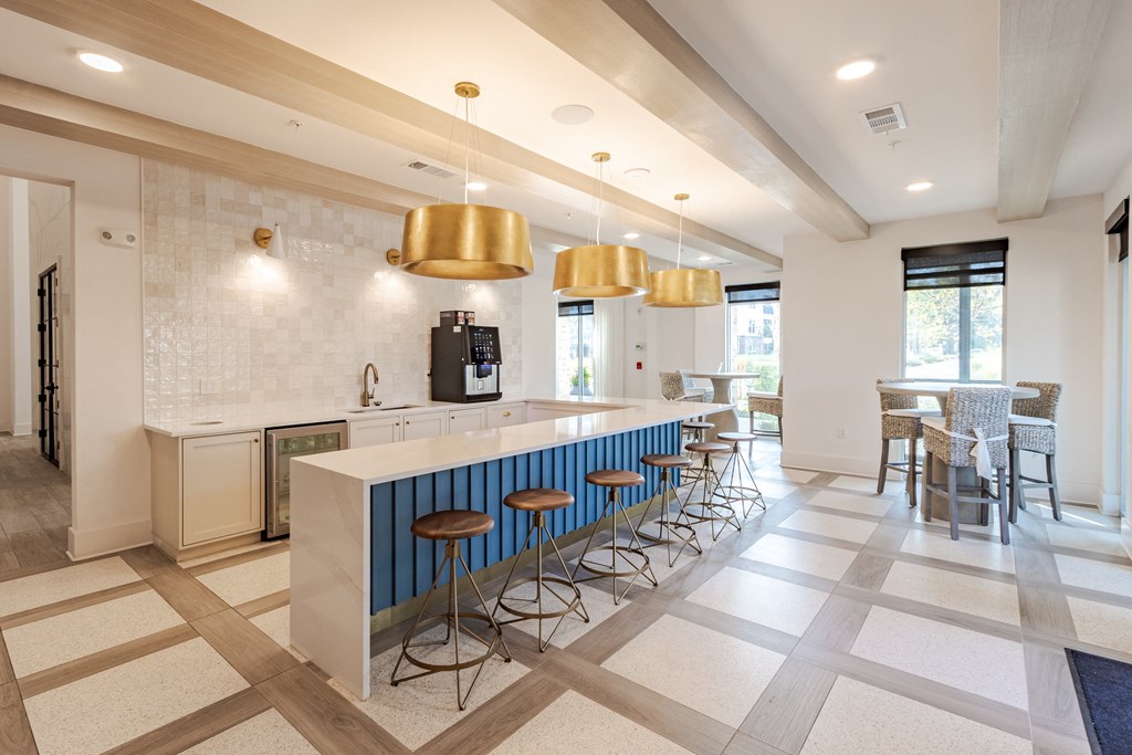 A kitchen with a white counter and blue bar stools.