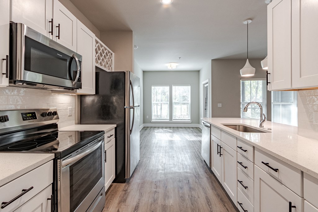 A kitchen with black appliances and white cabinets.