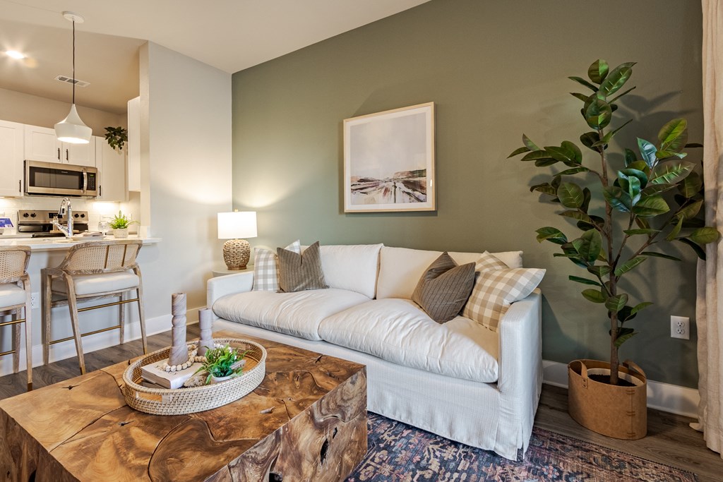 A living room with a white couch and a wooden coffee table.