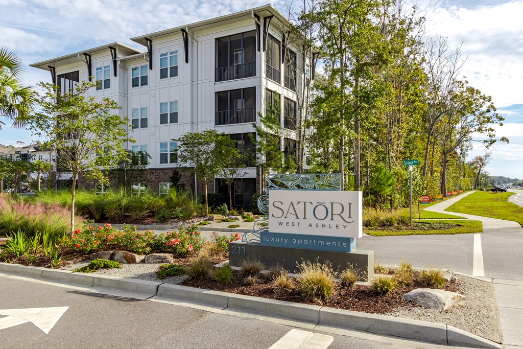 A Satori West Ashley apartment complex is shown with a sign in front.