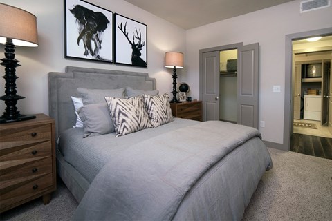 A bedroom with a large bed and two lamps.