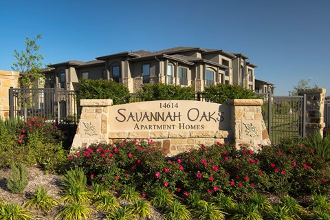 A sign for Savannah Oaks Apartment Homes is in front of a building.