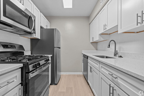 a kitchen with white cabinets and stainless steel appliances
