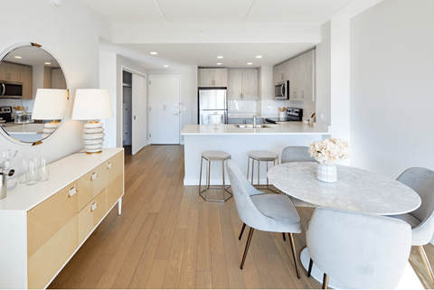 a dining room and kitchen with a marble table and white chairs