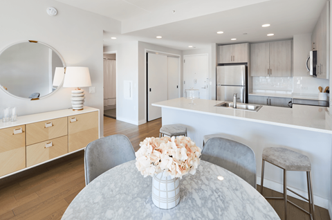 a dining room table with chairs and a vase of flowers