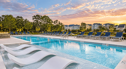 A swimming pool with a white design on the side and chairs around it.