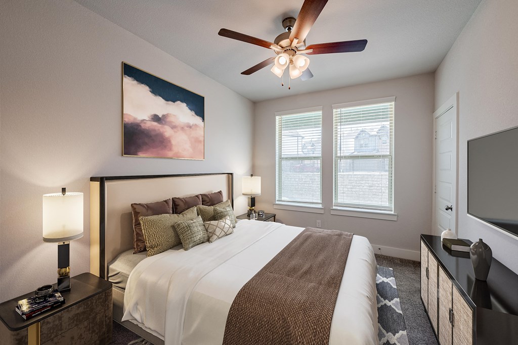 a bedroom with a large bed and a ceiling fan
