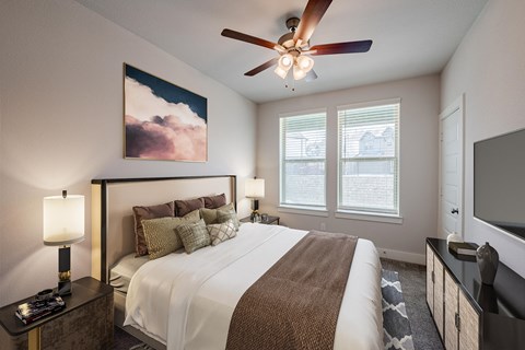 a bedroom with a large bed and a ceiling fan