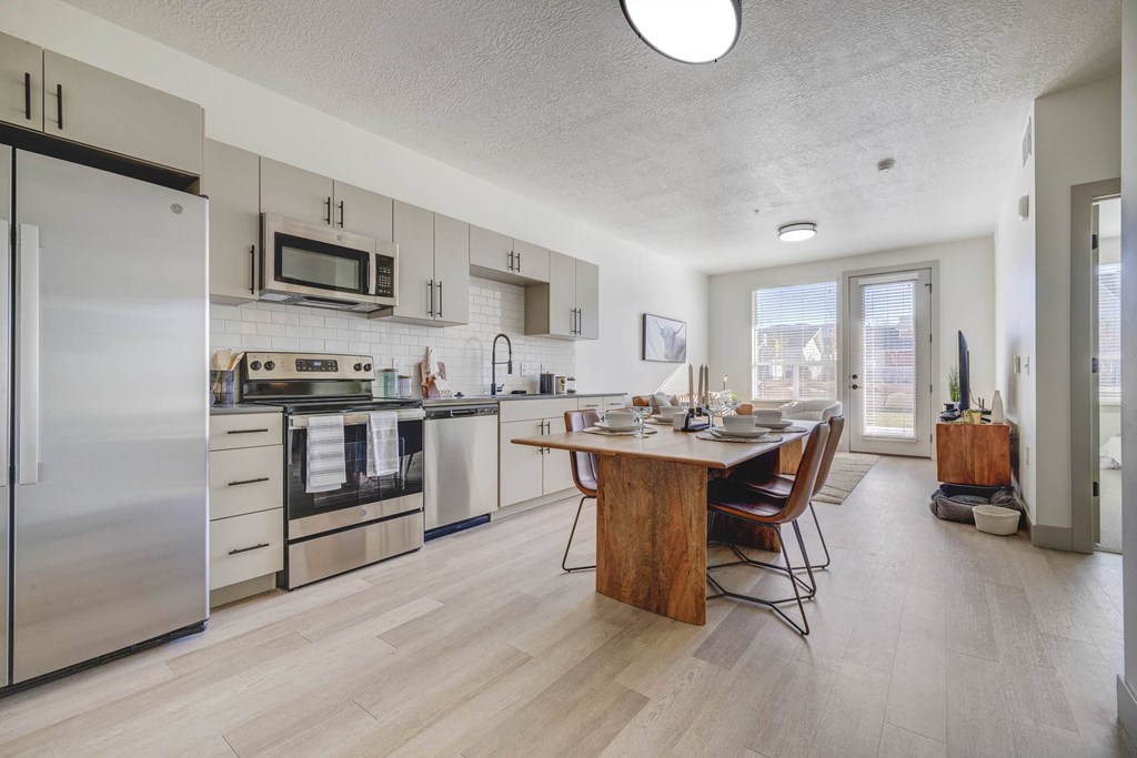 A modern kitchen with a dining table and chairs.