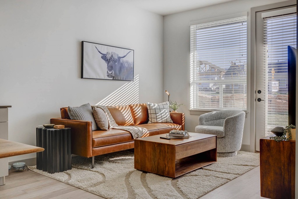 A living room with a brown leather couch and a coffee table.