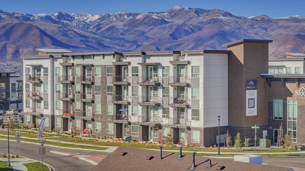 A large apartment complex with a mountain in the background.