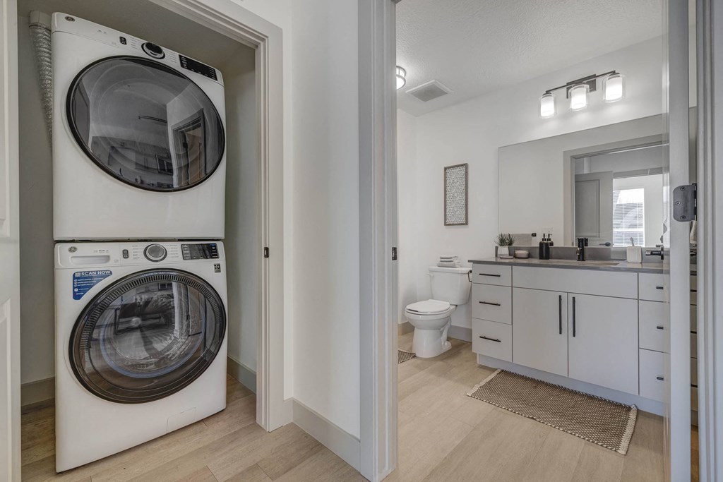 A white washing machine is in a small laundry room.
