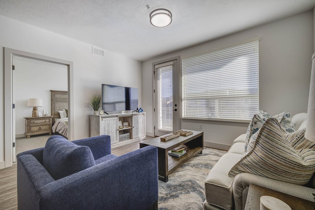 A living room with a blue chair and a white couch.