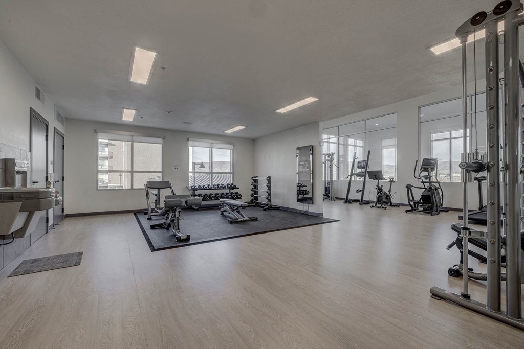 A spacious gym with a variety of equipment and a large mirror on the wall.