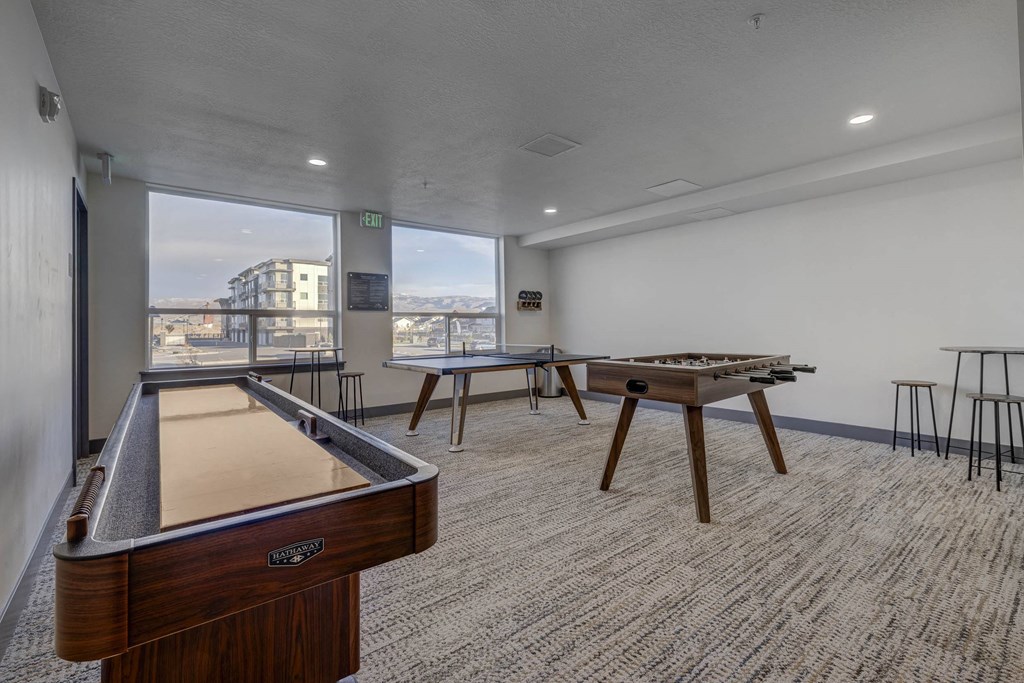 A room with a pool table and a view of the city.