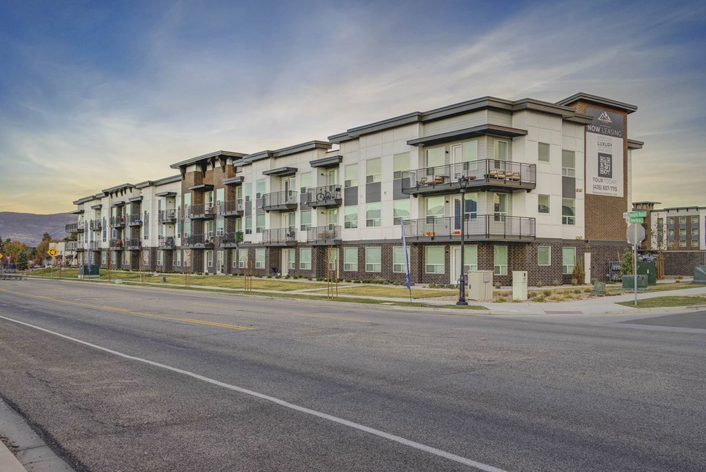 A street view of apartment buildings with a clear sky above.