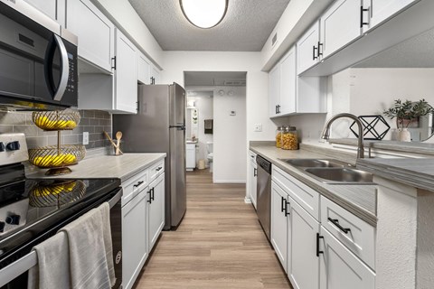 A kitchen with white cabinets and a black stove top oven.