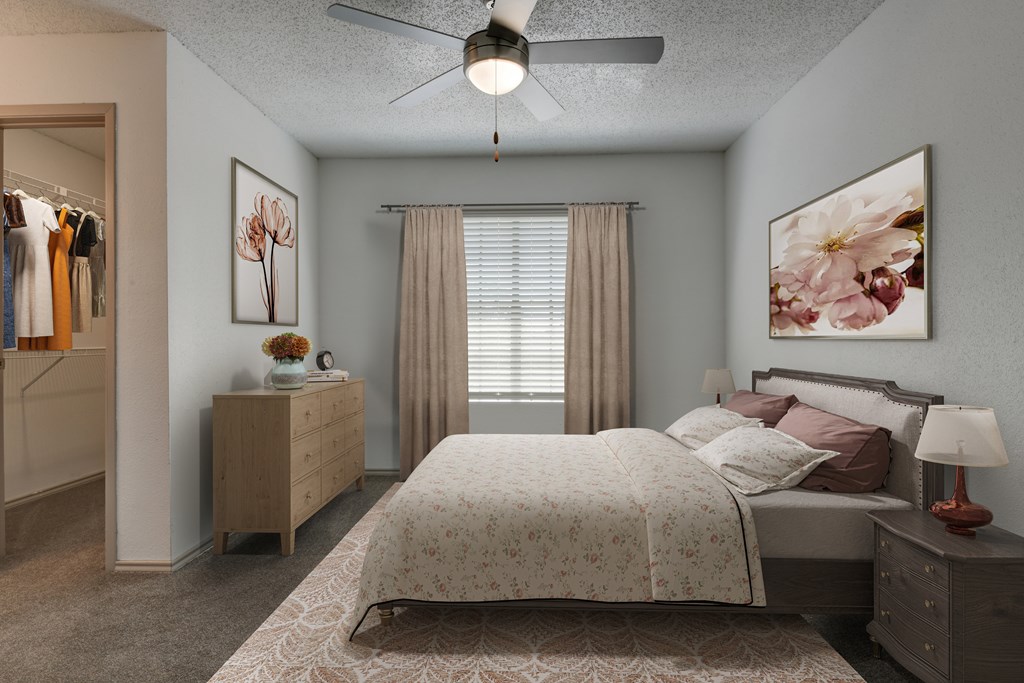A bedroom with a large bed and a ceiling fan.
