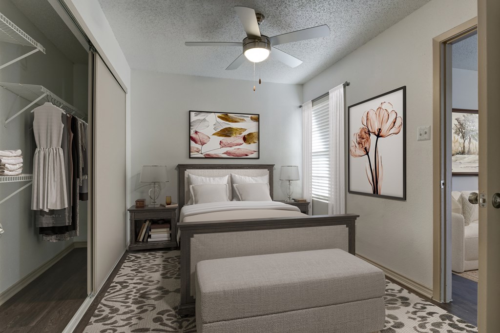 A bedroom with a bed, a bench, and a painting on the wall.