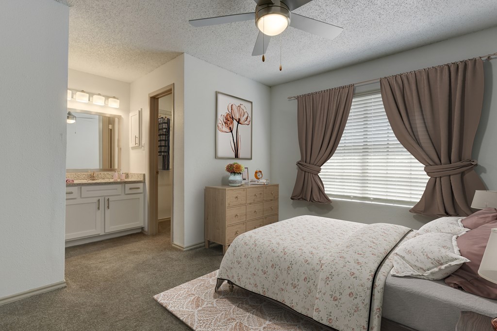 A bedroom with a bed, dresser, and a painting of flowers on the wall.
