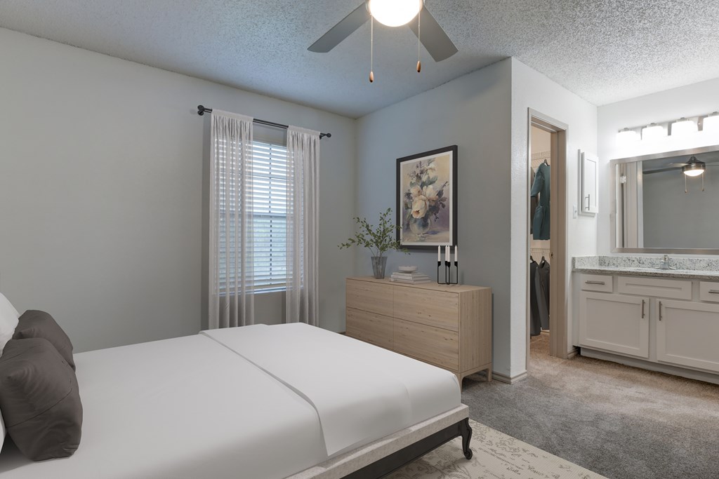 A bedroom with a bed, dresser, and mirror.