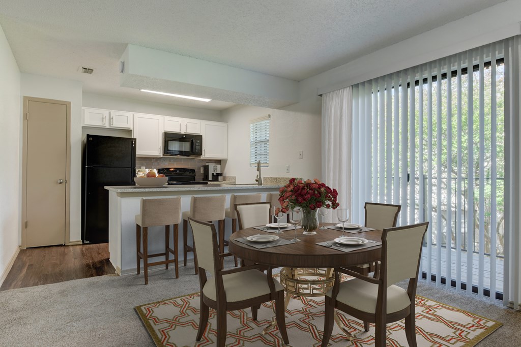 A dining room with a table set for four.