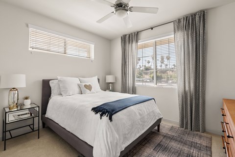 A bedroom with a large bed and a ceiling fan.