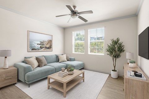 A living room with a blue couch, a wooden coffee table, and a painting on the wall.