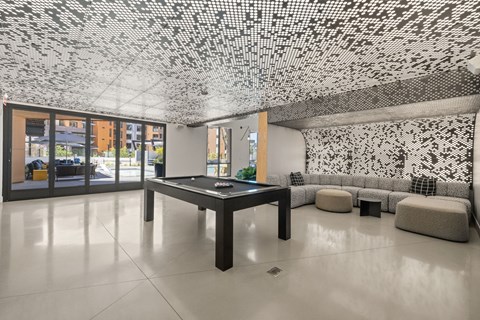 A black and white tiled ceiling in a spacious room with a pool table.