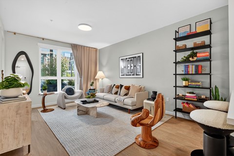 A living room with a white couch, a coffee table, and a bookshelf.
