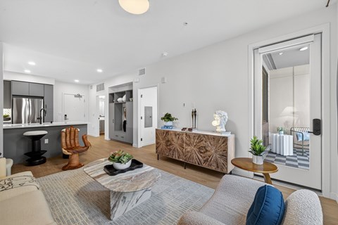 A modern living room with a grey rug and a wooden coffee table.