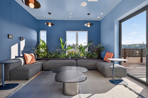 A modern living room with a grey coffee table and grey couches.