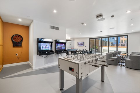 A room with a foosball table and a large window.