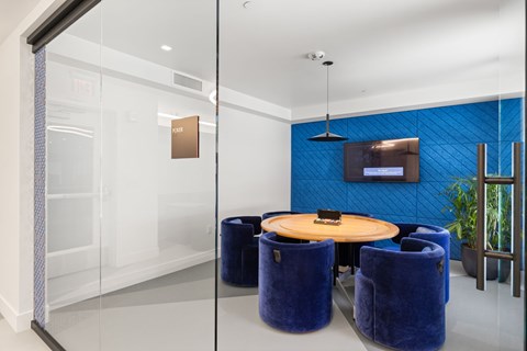 A glass wall separates a white room from a blue room.