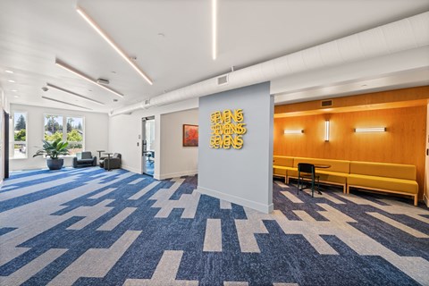 A room with a carpet and a wall with a painting on it.